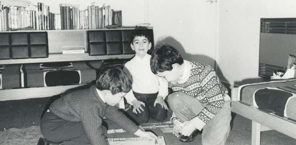 Printed black and white of Barrie and Marion Liss’s children playing a board game on the floor, around 1970