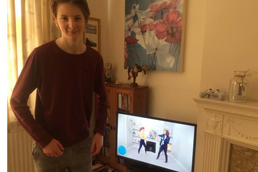 Person standing in front of TV showing PE with Joe