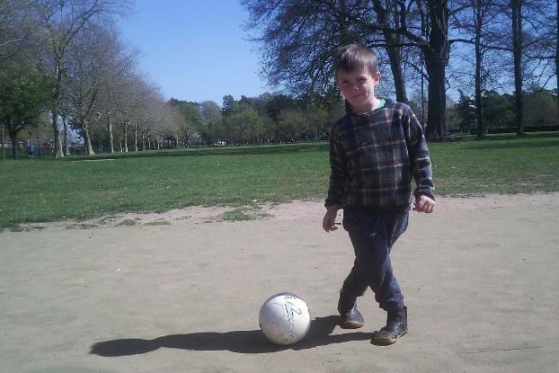 A young child playing football