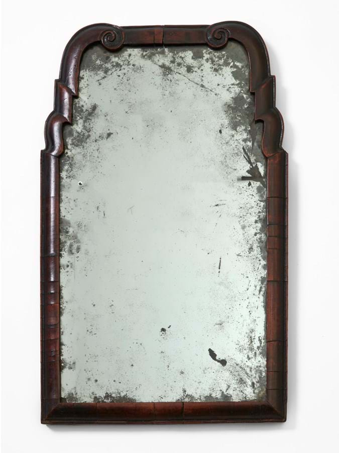 Scuffed mirror with wooden frame.