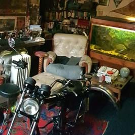 Motorbike in front on arm chair and fish tank