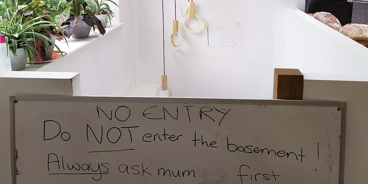 A white board that reads 'No Entry: do not enter the basement. Always ask mum first.'