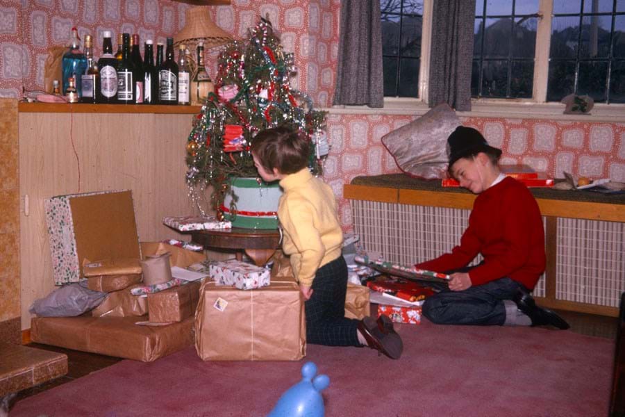 Children looking at Christmas gifts underneath a tree
