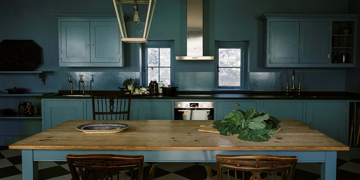 A kitchen table with green vegetables on it