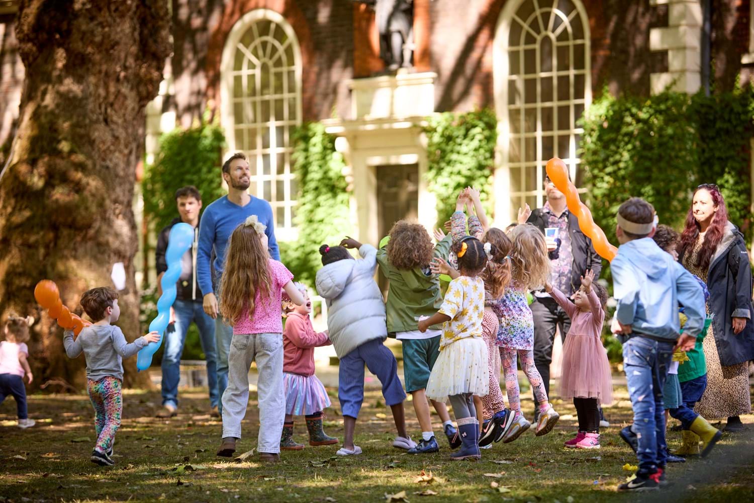 Children are having fun with balloons in Kingsland Garden at Museum of the Home.