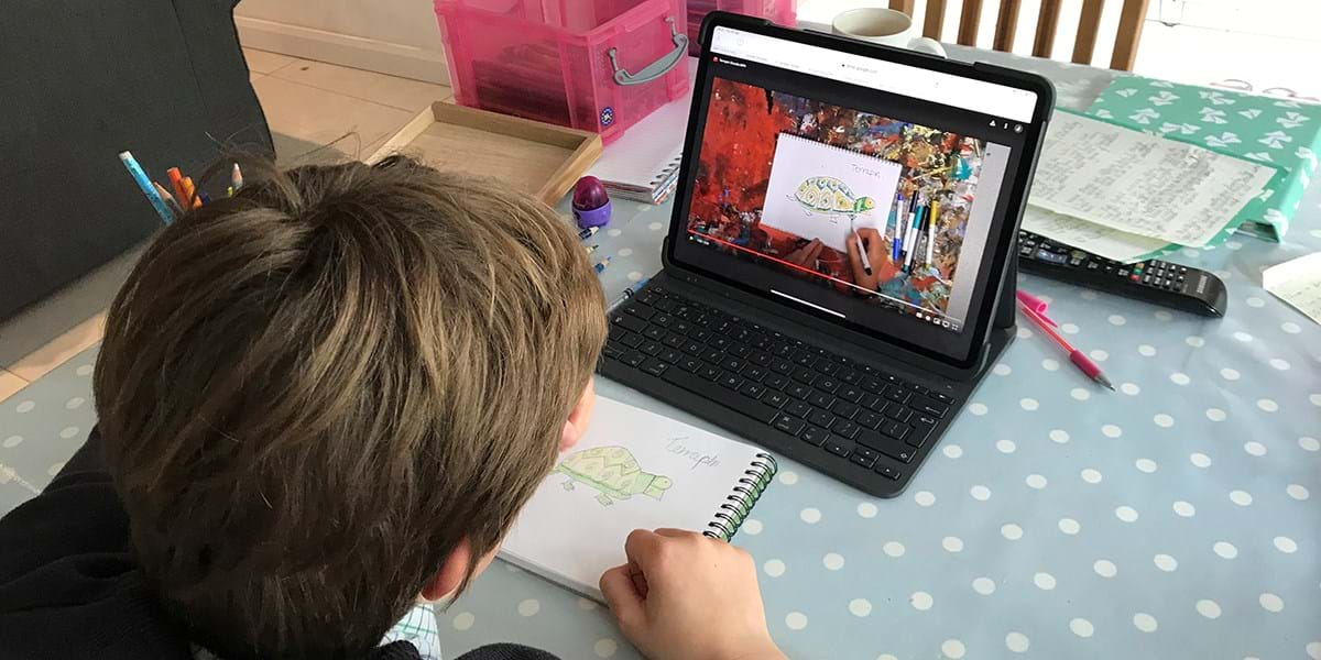 A person sat at a table with a polka dot tablecloth, using a laptop