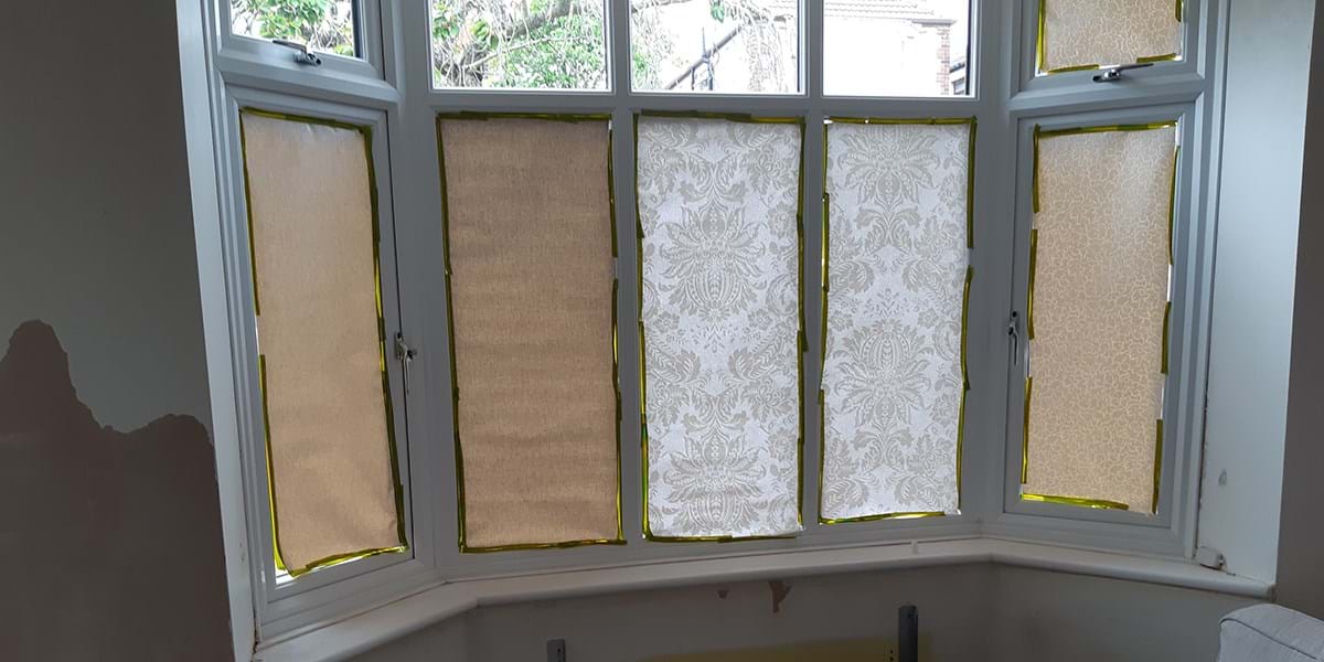 A set of windows with paper covering the lower panes 