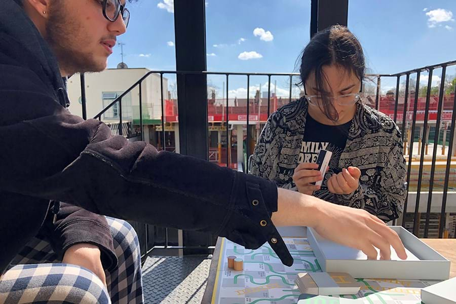 Two people playing board games on a balcony