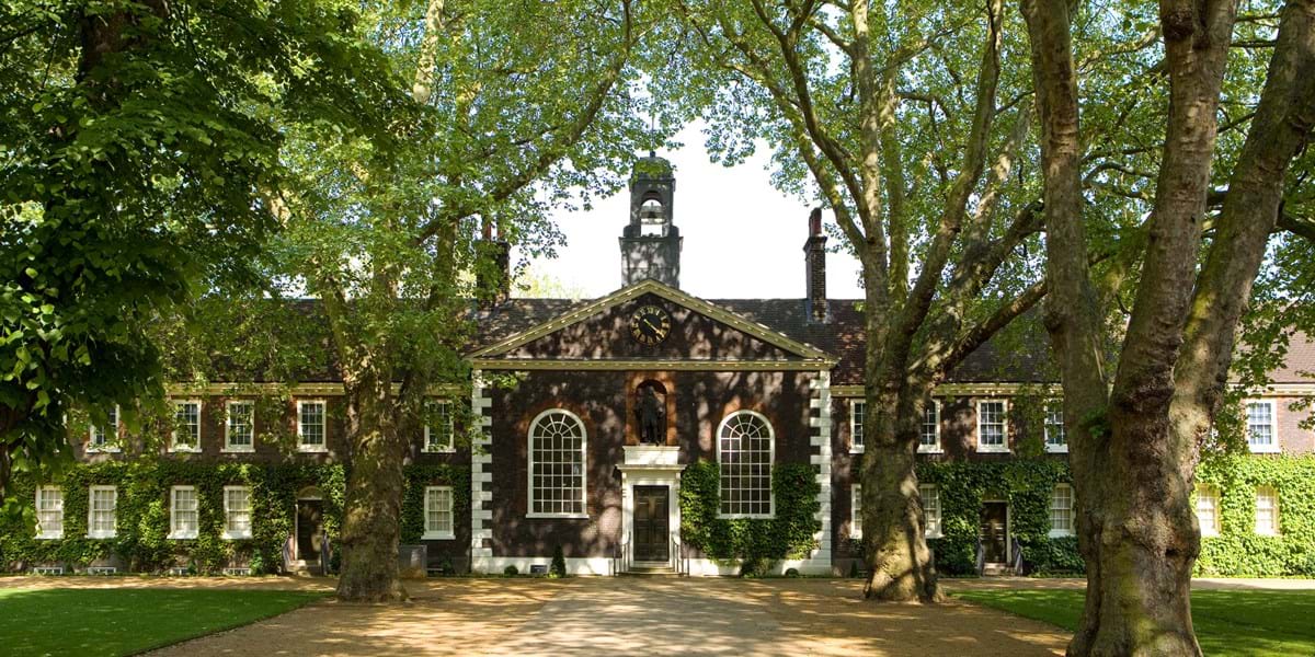 A brick building surrounded by London plane trees