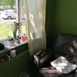 Large brown armchair by the window, view of cars outside
