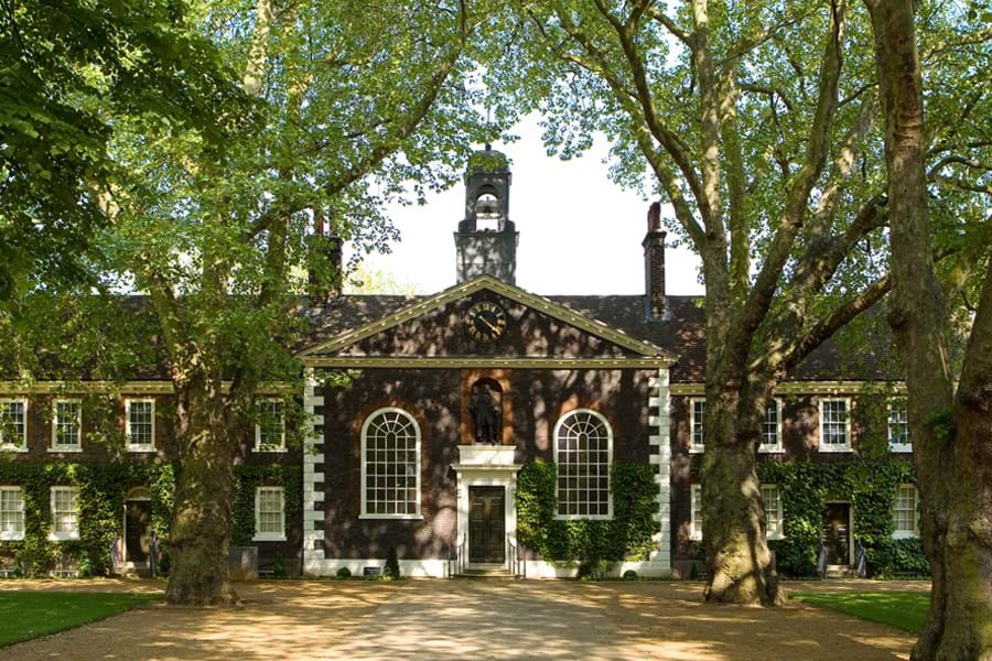 Exterior of a brick building with lush plane trees