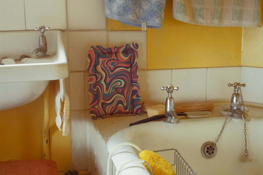 A bath and sink in a yellow bathroom