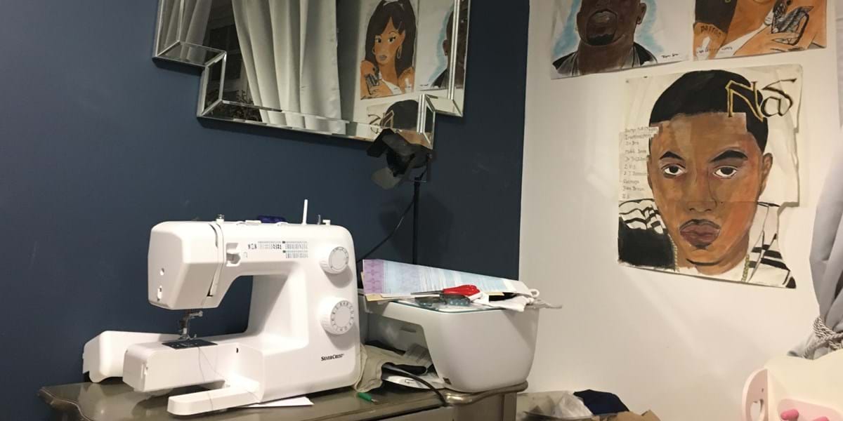 White sewing machine with artworks on the wall behind