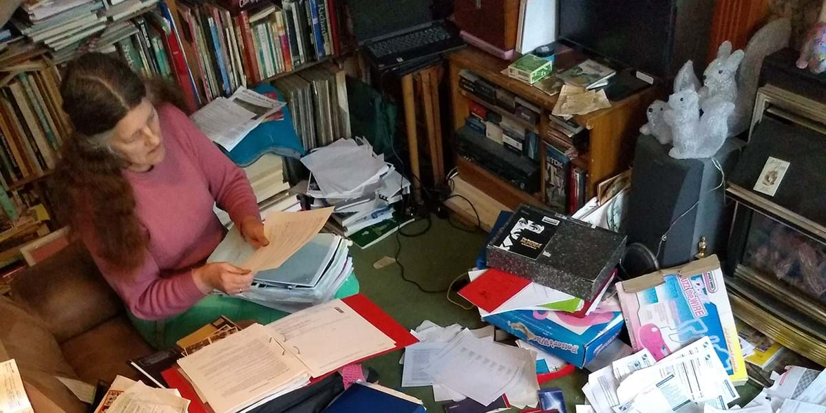 Person looking at papers in room filled with books