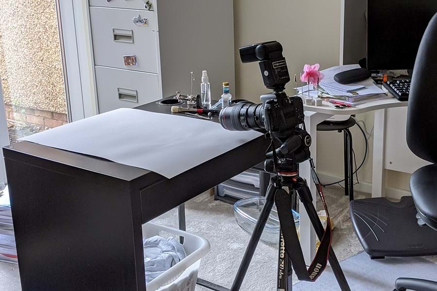 A camera set up on a tripod overlooking a desk