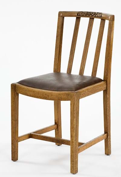 A utility chair made of wood with a leather seat covering