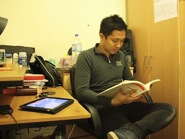 Nguyen sat at his desk reading a book