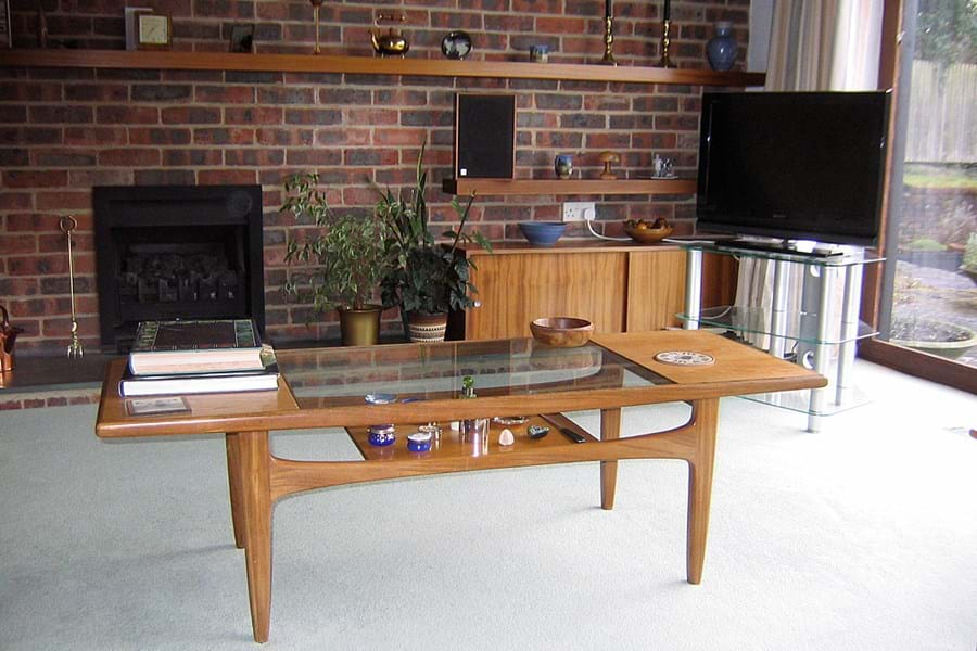 A living room with an exposed brick wall, flatscreen television and low coffee table.