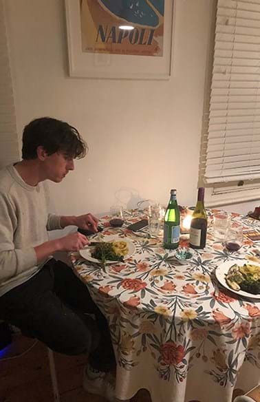  Person eating a meal at a table with floral tablecloth 