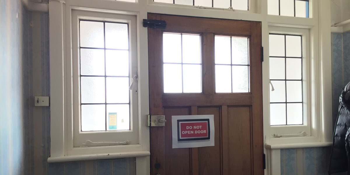 A door with a sign that reads 'do not open door' in capital letters
