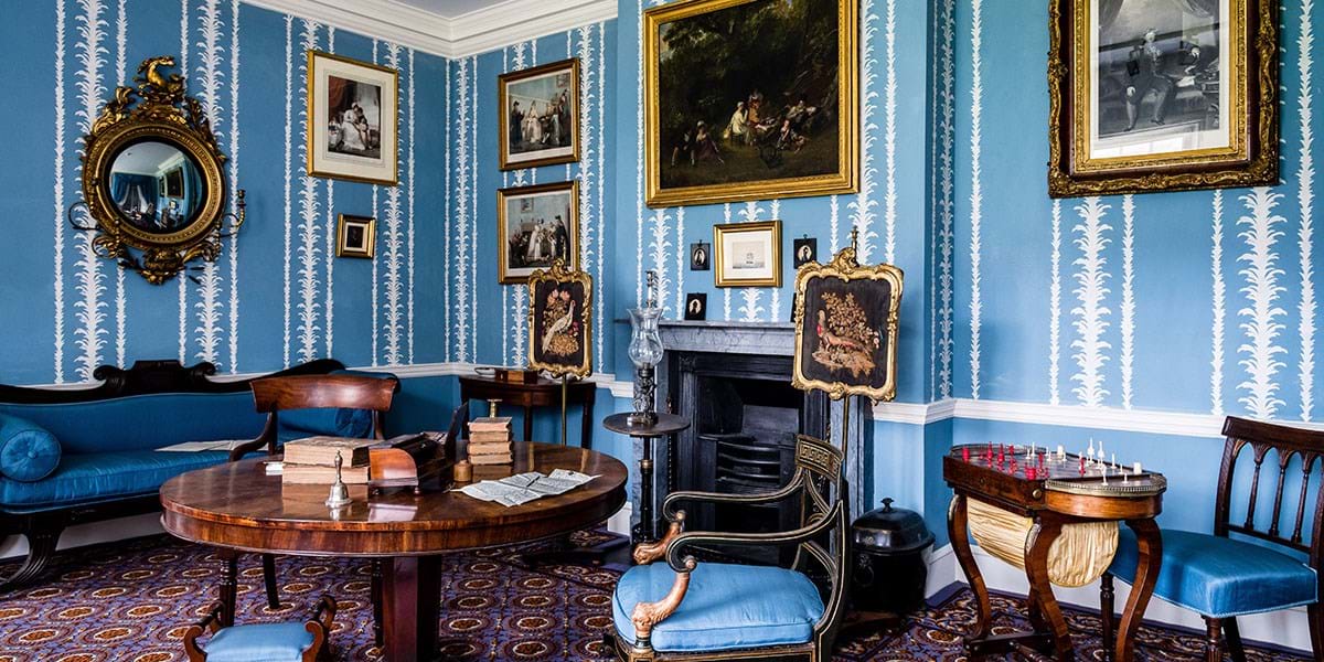 Blue room with blue sofa, upholstered blue chairs and chess board
