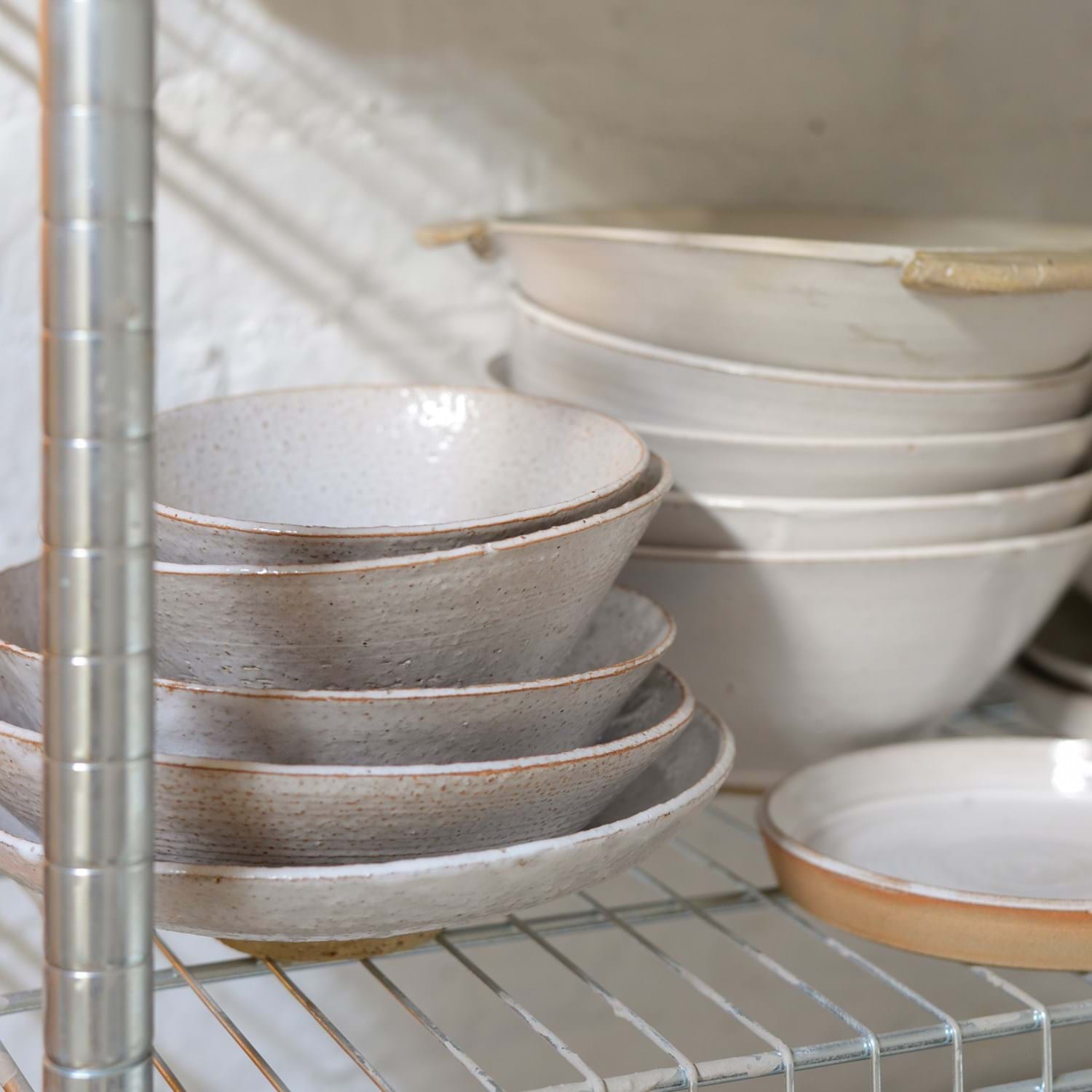 Ceramic bowls and plates on a racking shelf