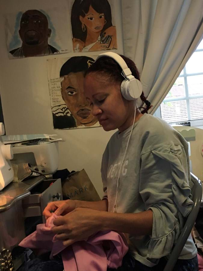 Person wearing headphones working at a sewing machine