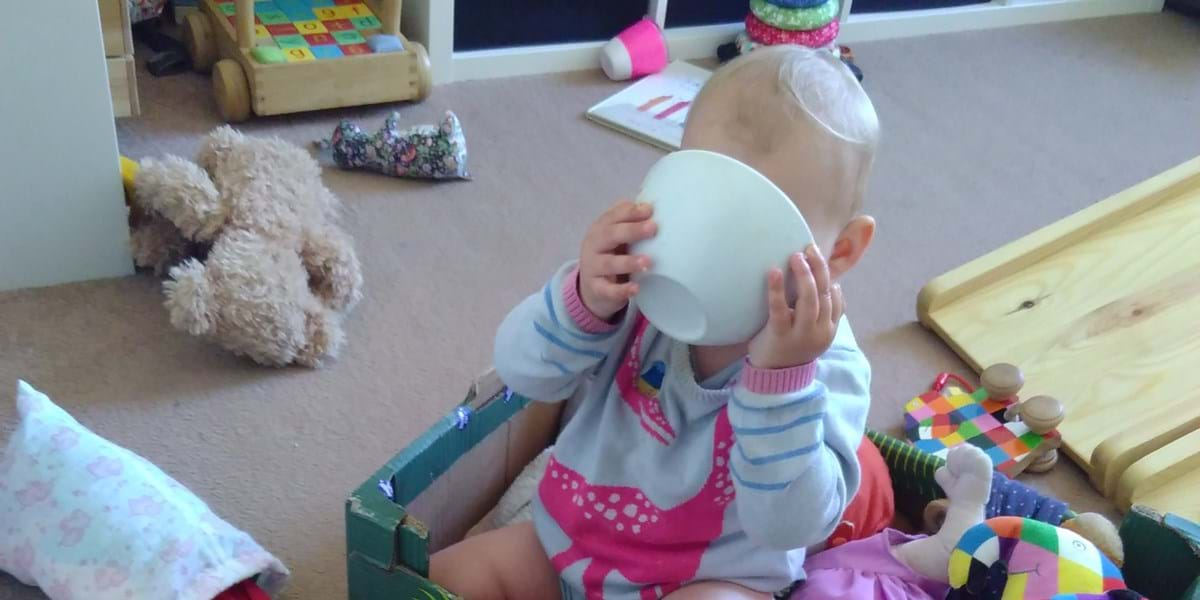 Baby holding bowl up