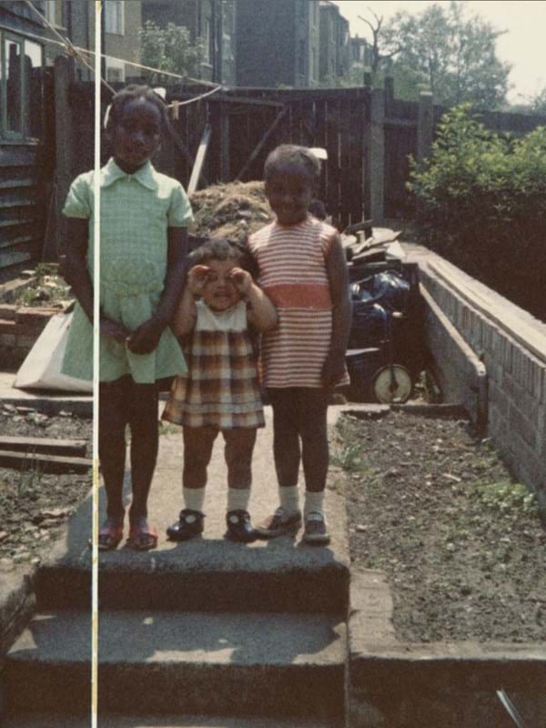 Three children on steps in the back garden