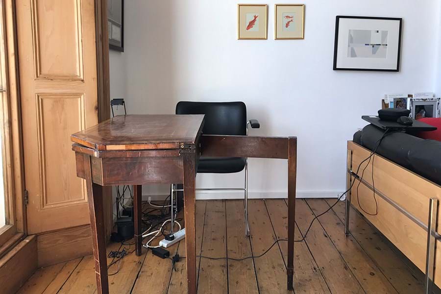 Wooden desk in front of white wall
