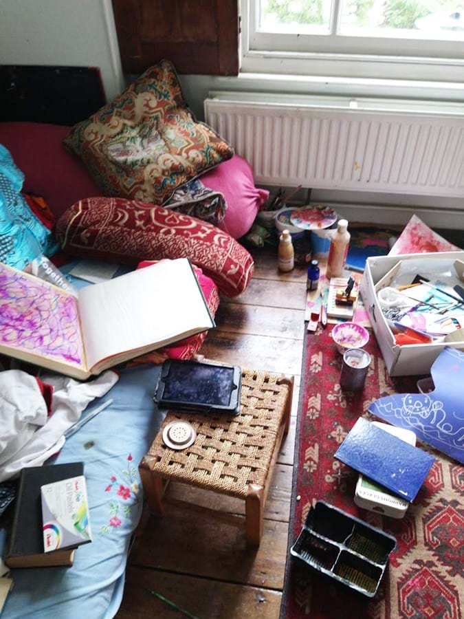 Various art items spread over a sofa and floor in the front room