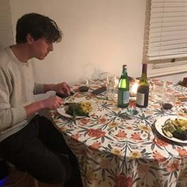  Person eating a meal at a table with floral tablecloth 