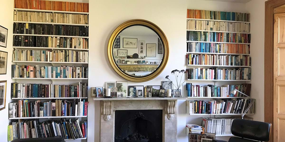 View of bookshelves mirror and fireplace