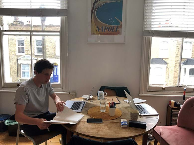 Person working at dinner table with two laptops out