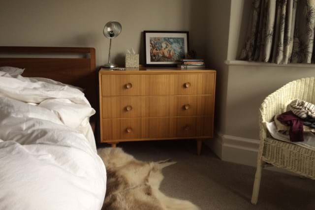 Chest of drawers next to a bed 