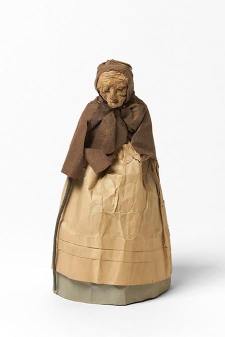 Paper doll representing an old woman with basket of flowers and walking stick
