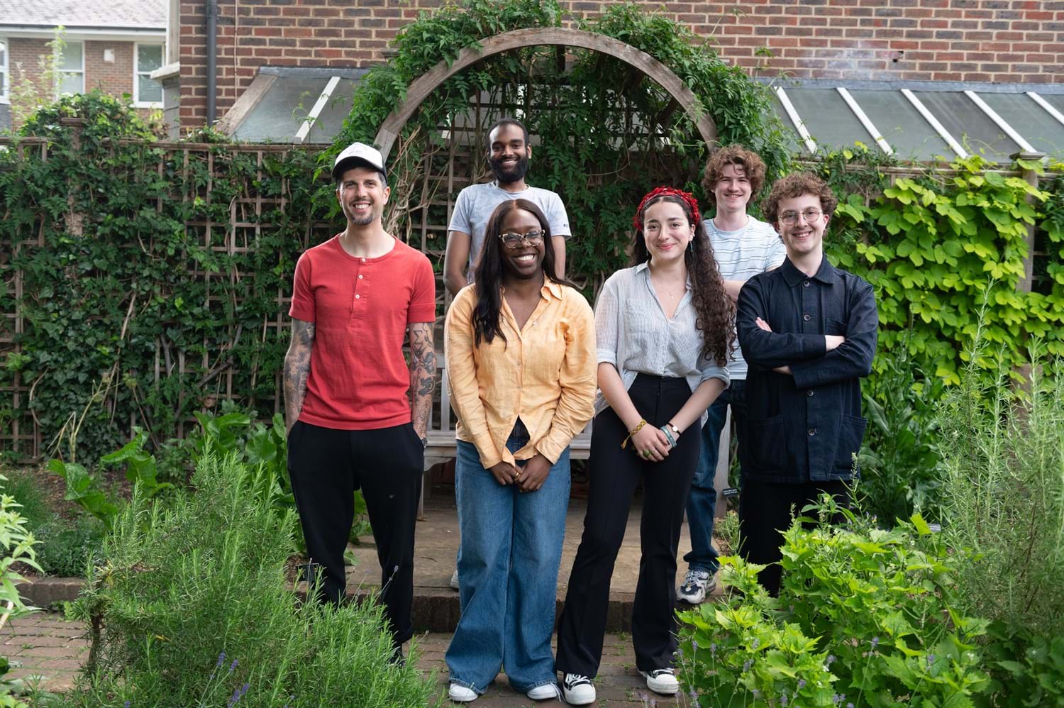A group of young people standing in a garden smiling