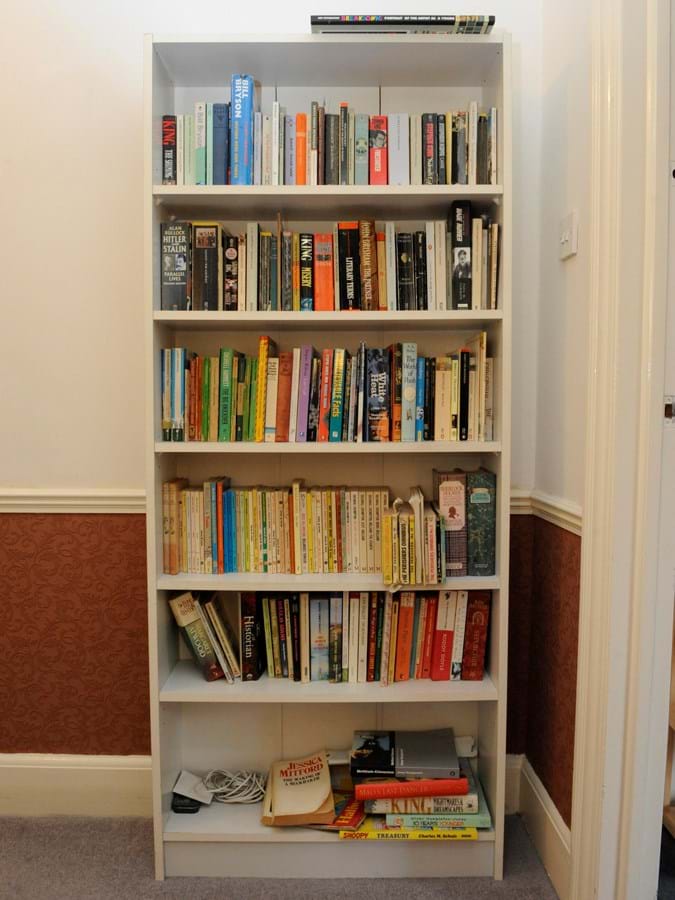 A large white bookcase filled with books