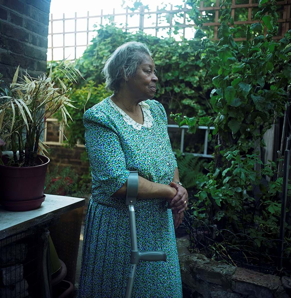 A person using crutches, standing in a garden