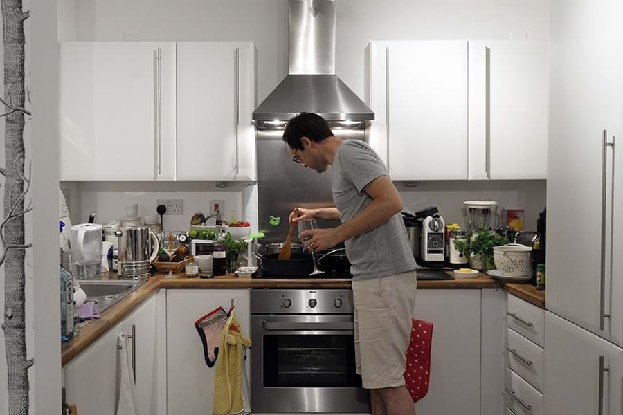 Person cooking in a white kitchen