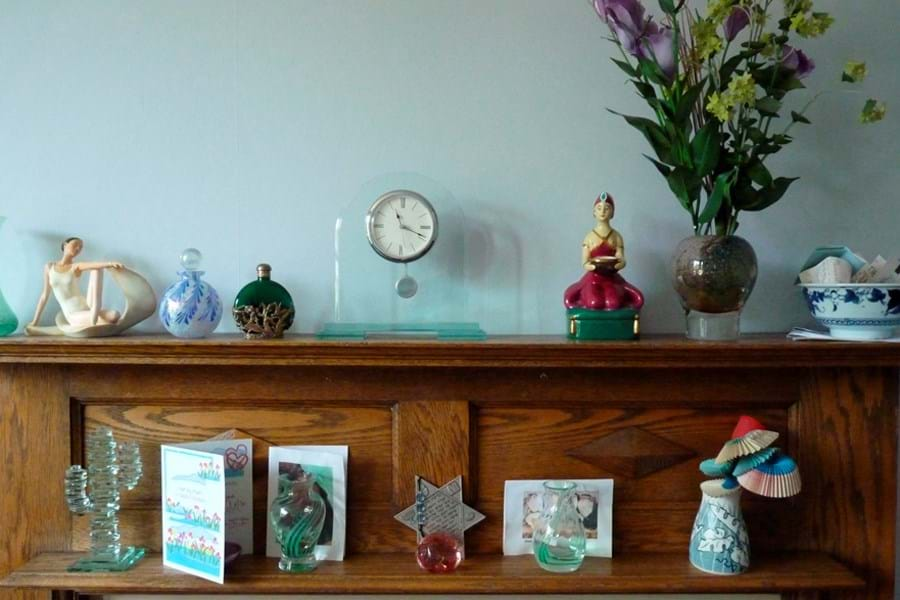 A wooden mantelpiece decorated with flowers and ornaments. 