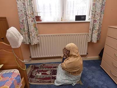 A person praying on an Islamic prayer mat 