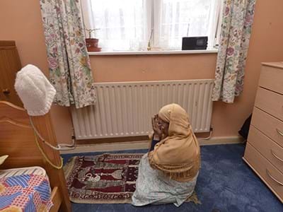 A person praying on an Islamic prayer mat