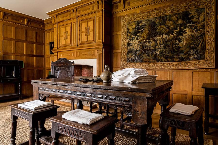 Laundry hanging in front of a fire place in a wood paneled room