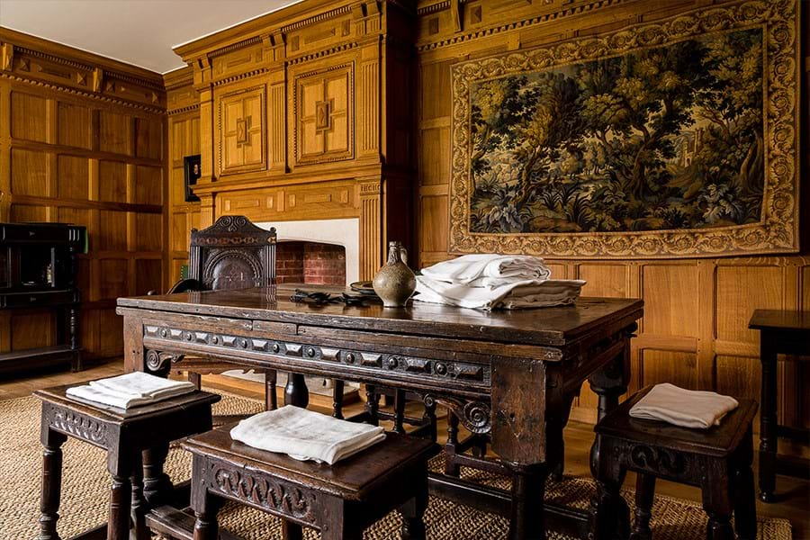 Laundry hanging in front of a fire place in a wood paneled room 