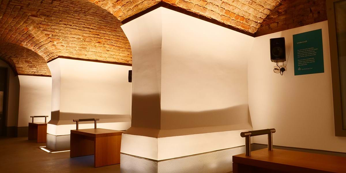 The arches of the Undercroft lit from the floor with benched seating