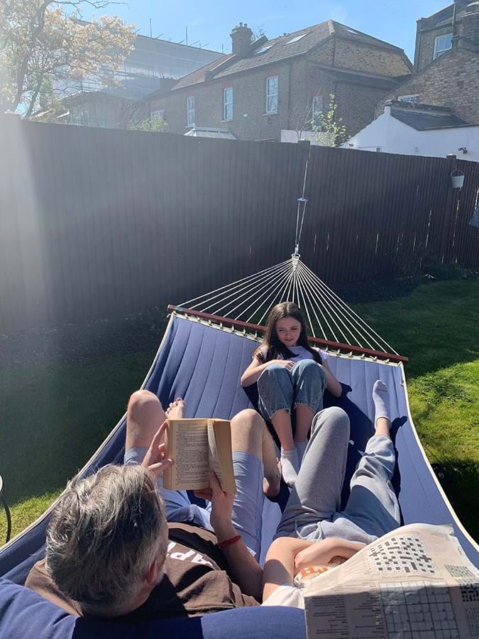 Three people in a hammock reading