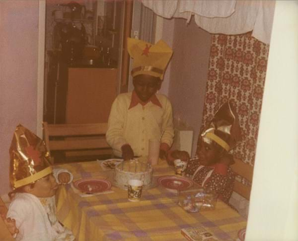 Three children about to share birthday cake