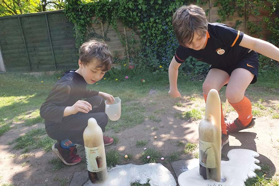 Two children with overflowing bottles of fizzy drinks 