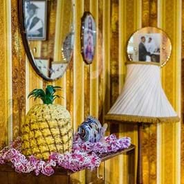 Interior of 1970s room with pineapple decoration and yellow wallpaper